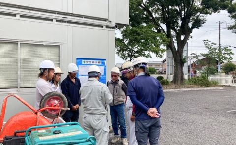 クリップボードを持ち建物の外壁を点検する担当者