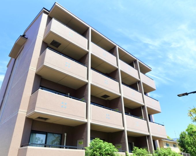 青空のもとに建つマンション外観