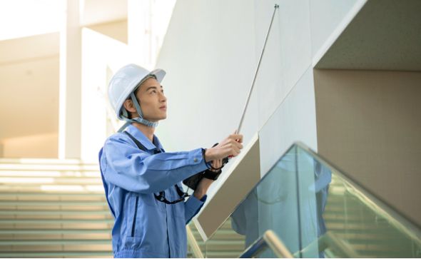 マンションの壁面を点検する作業員